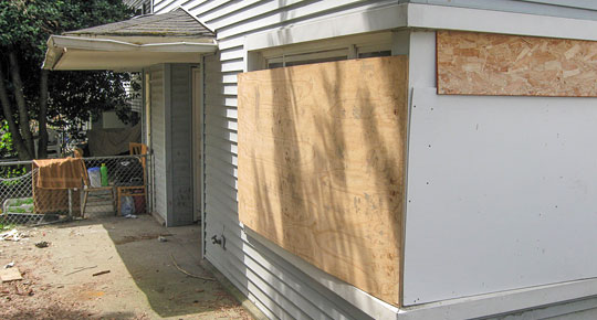 Photo by Emran Nuru, age 16 "Some windows at Yesler Terrace are now covered with boards. The family who once lived here had sun shining into their home in the afternoons. The fences around Yesler Terrace are also old and bent with age."