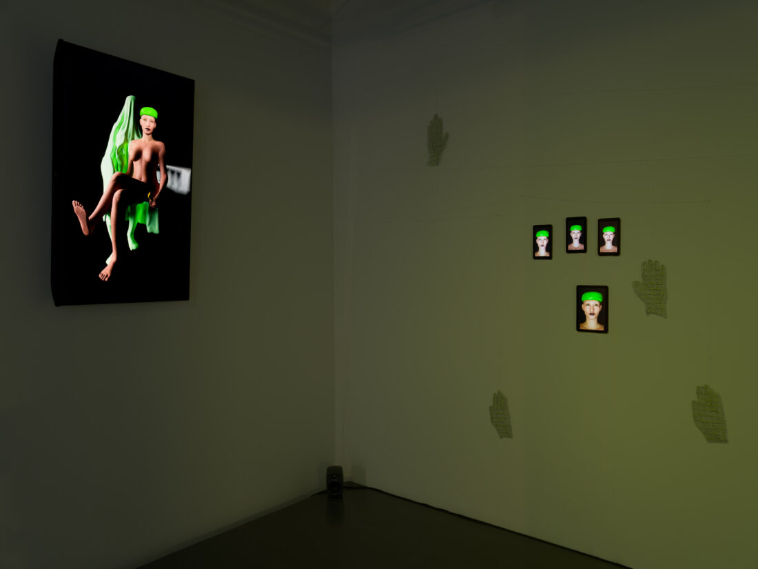 A dark gallery space displays a digital artwork of a stylized figure with green hair on the left wall and four smaller digital portraits of the same figure on the right wall, with hand-shaped outlines beneath them.